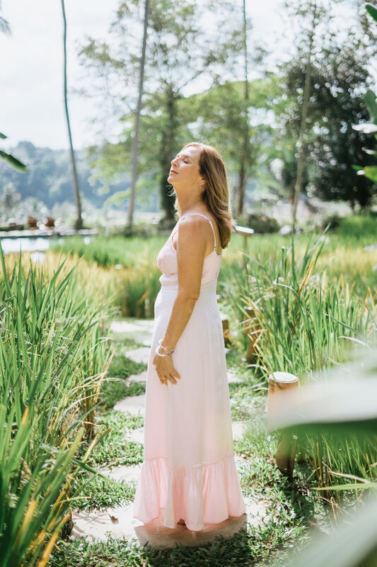 Julie Wright Halbert on a stone path, head tilted back to the light