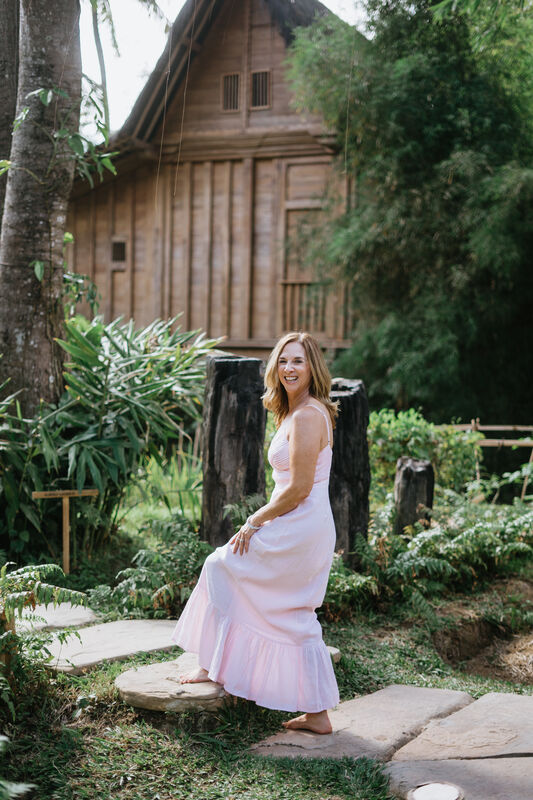 Julie Wright Halbert walking a stone path past a timber pavilion